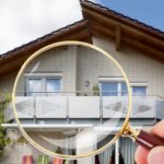 Hand With Magnifying Glass Over House